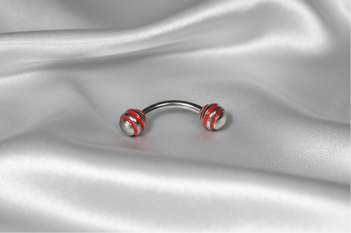 Red Striped Steel Ball Eyebrow Ring in 316l stainless steel.