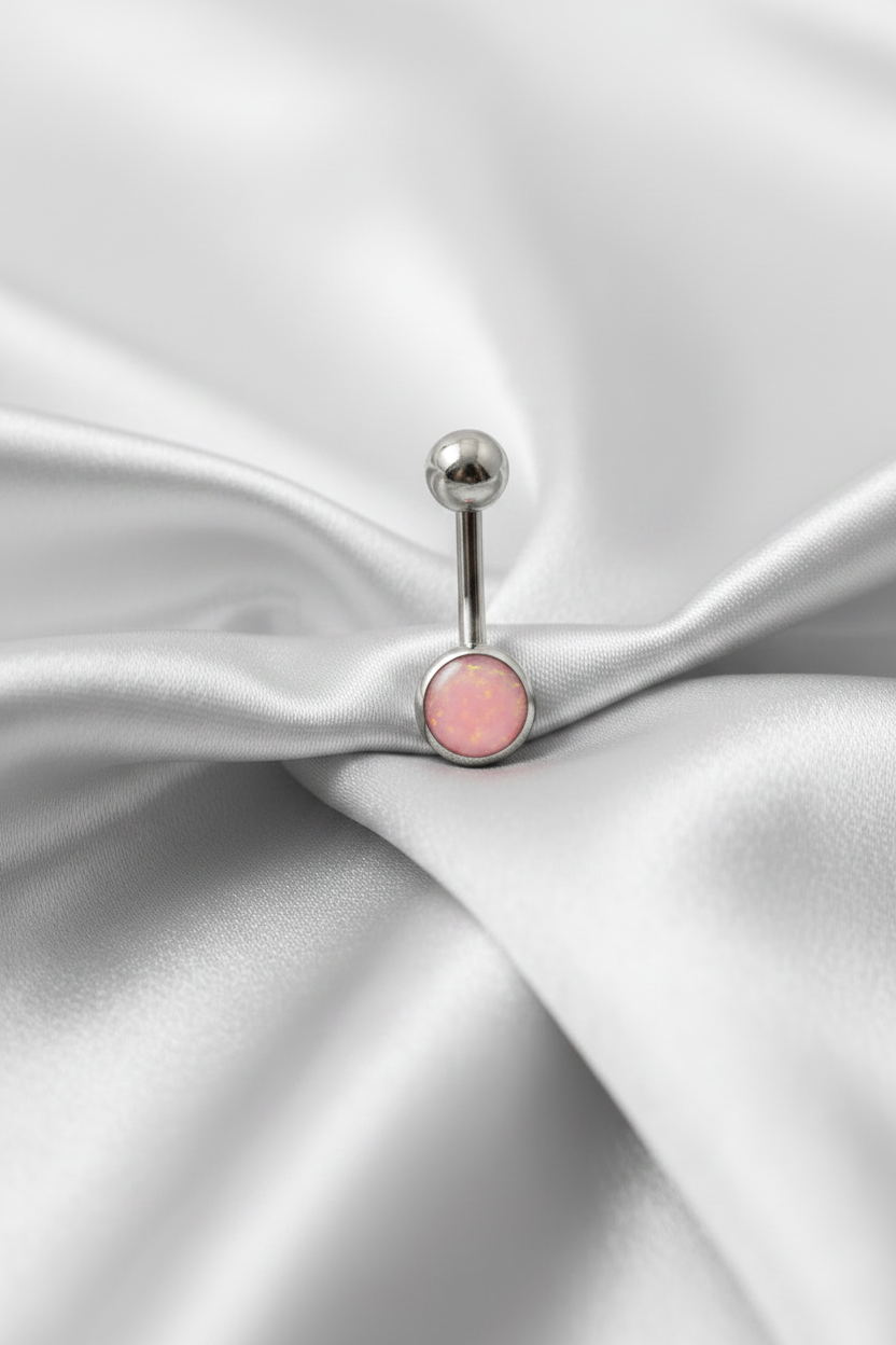 Pink Opal Belly Button Ring in 316l stainless steel on silver silk fabric.