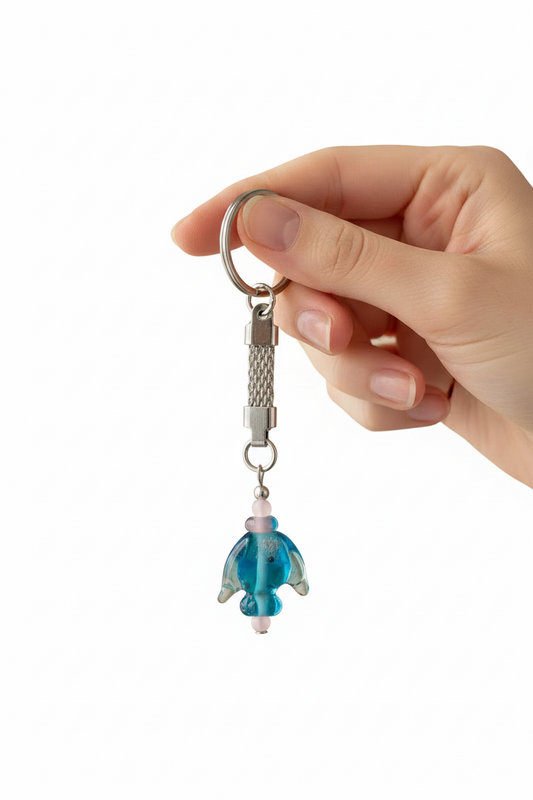 Aqua Glass Fish Handmade Steel Plated Keychain held by a hand showing scale.