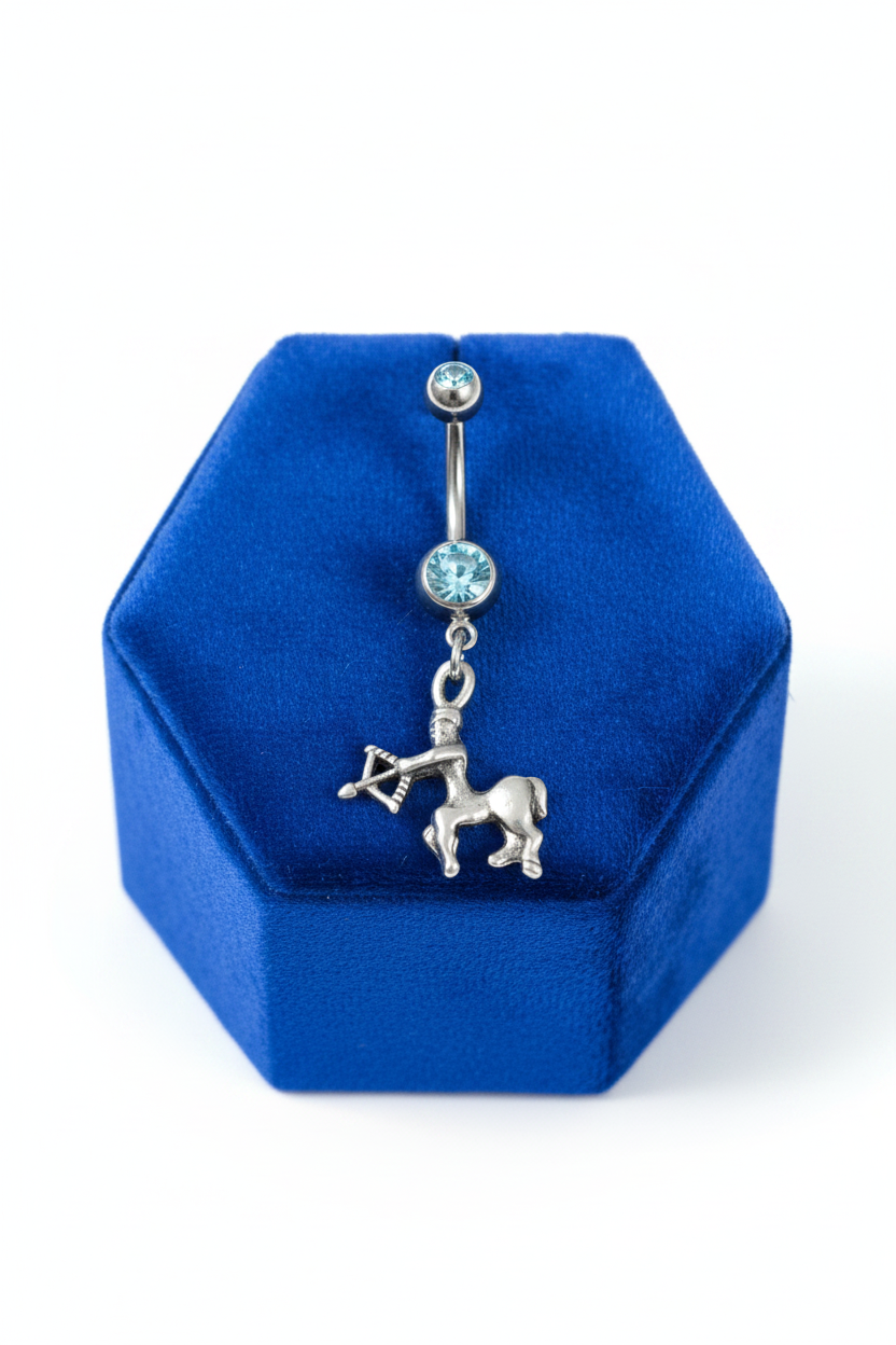 Blue Crystal Sagittarius Belly Button Ring in 316l stainless steel on a blue velvet jewelry display.