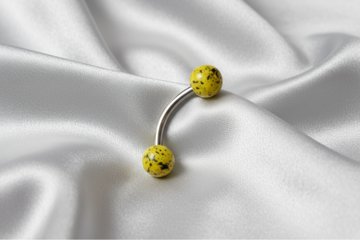 Yellow Black Speckled Acrylic Eyebrow Ring in 316l stainless steel.