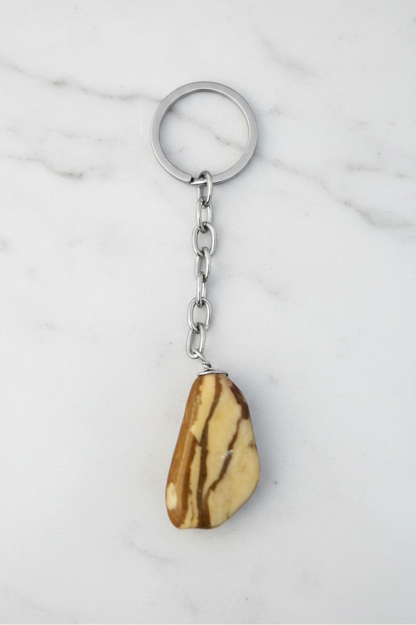 Brown and White Agate Natural Earth Stone Handmade Steel Plated Keychain on a white marble surface.