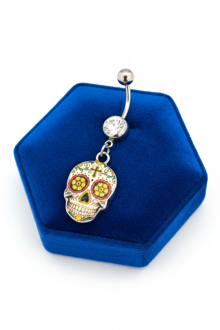 Clear Crystal Sugar Skull Belly Button Ring in 316l stainless steel laying on a blue velvet jewelry display.