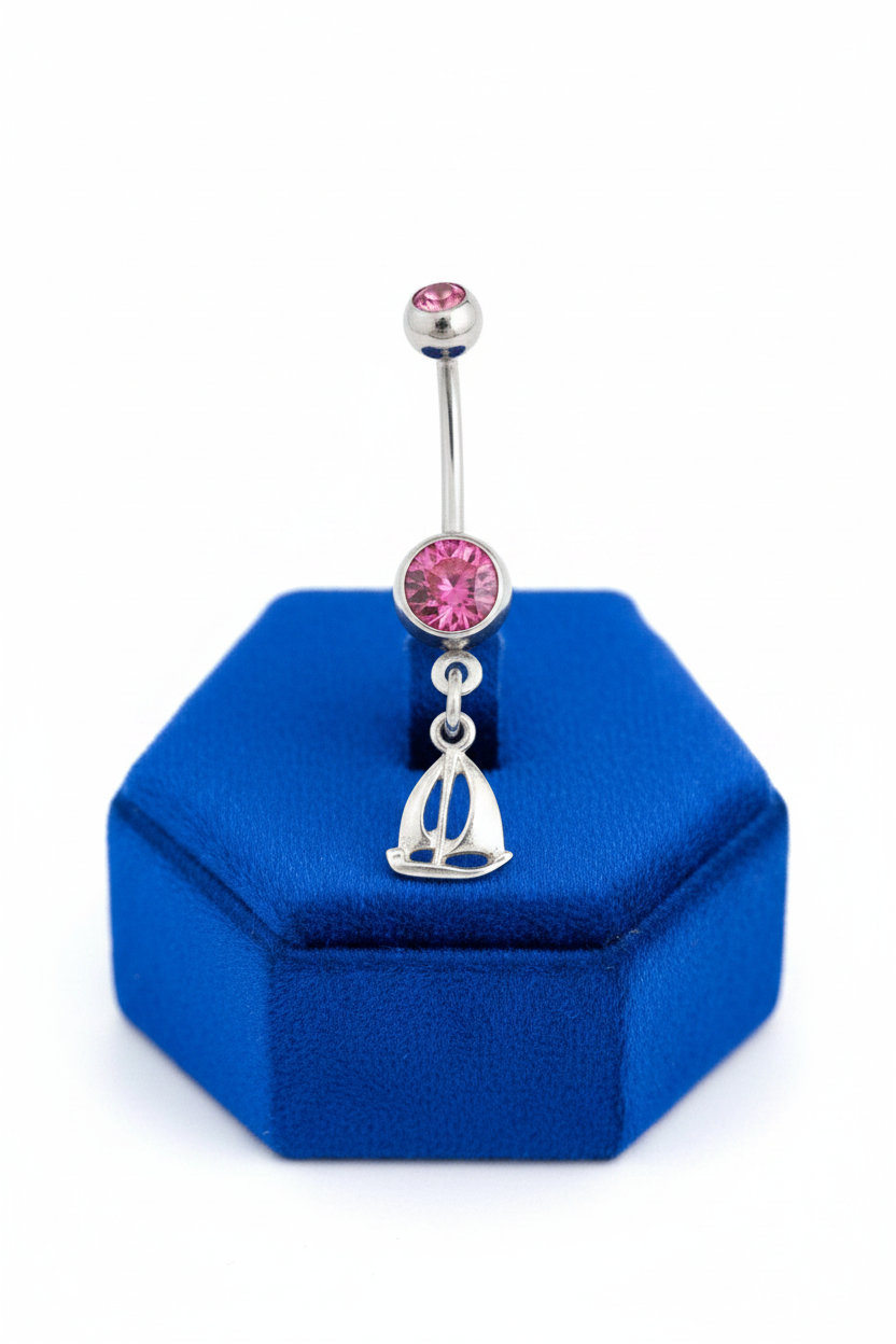 Pink Crystal Sterling Silver Sailboat Belly Button Ring in 316l stainless steel on a blue velvet jewelry display.