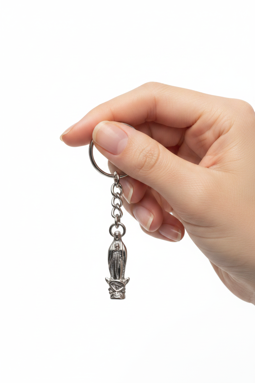 Virgin Mary Handmade Pewter Charm Keychain held by a hand showing scale.