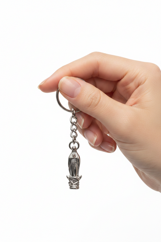 Virgin Mary Handmade Pewter Charm Keychain held by a hand showing scale.