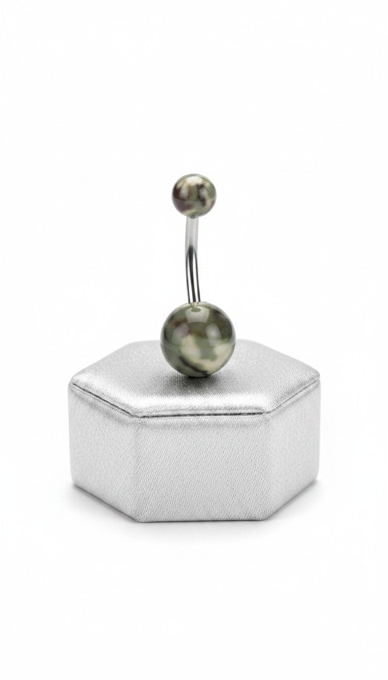 Green Camouflage Acrylic Belly Button Ring in 316l stainless steel on a silver jewelry display.