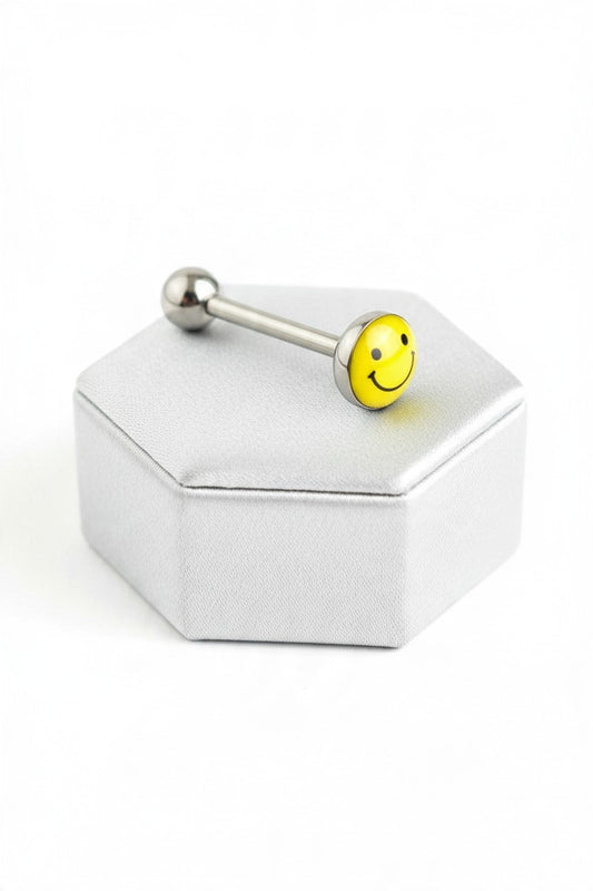 Yellow Happy Face Tongue Barbell in 316l stainless steel on a silver silk jewelry display.