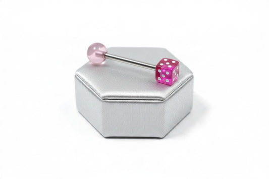 Pink Fuchsia Dice Acrylic Tongue Barbell in 316l stainless steel on a silver silk jewelry display.