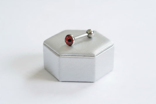 Red Eyeball Tongue Barbell in 316l stainless steel on a silver silk jewelry display.