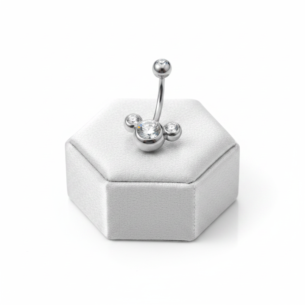Clear Crystal Belly Button Ring in 316l stainless steel on a silver silk jewelry display upright position.