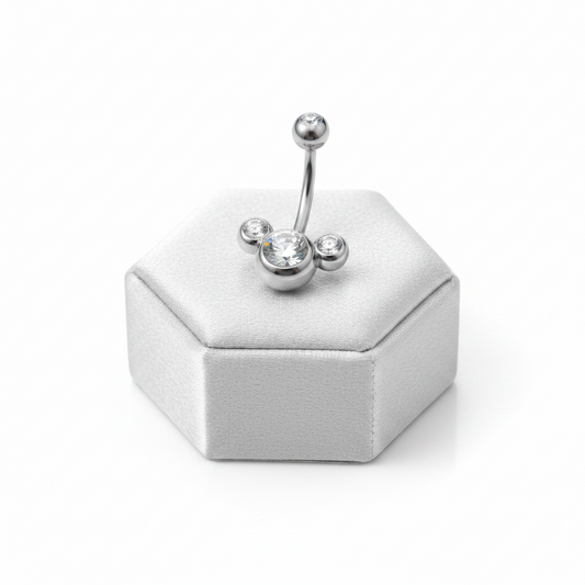 Clear Crystal Belly Button Ring in 316l stainless steel on a silver silk jewelry display upright position.