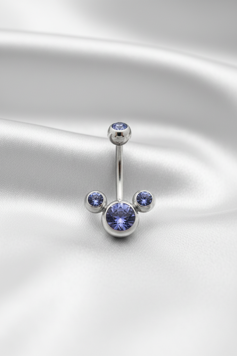 Purple Crystal Belly Button Ring in 316l stainless steel on silver silk fabric.