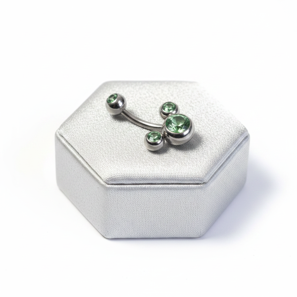 Green Crystal Belly Button Ring in 316l stainless steel on a silver jewelry display.