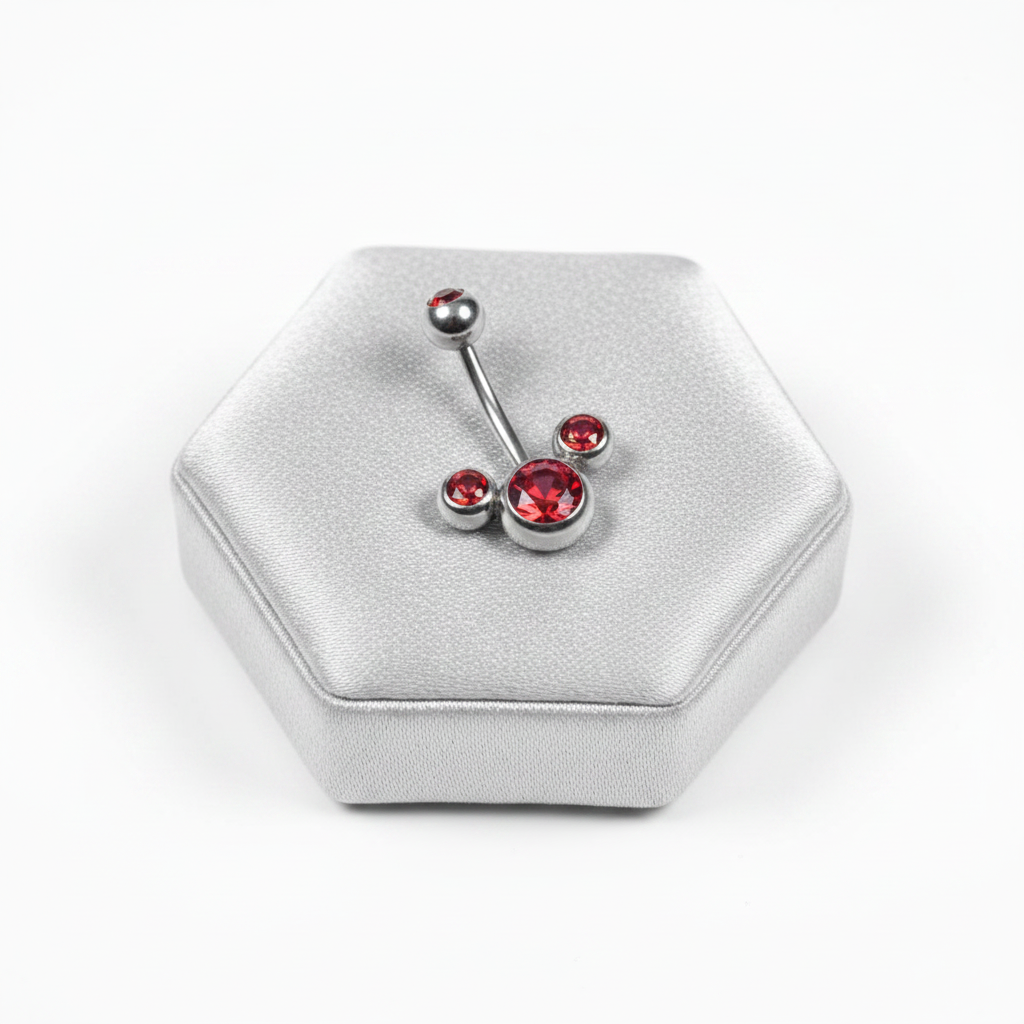 Red Crystal Belly Button Ring in 316l stainless steel on a silver jewelry display.