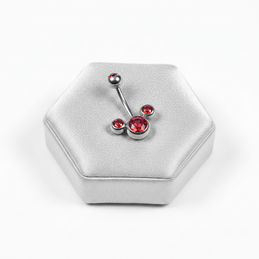 Red Crystal Belly Button Ring in 316l stainless steel on a silver jewelry display.