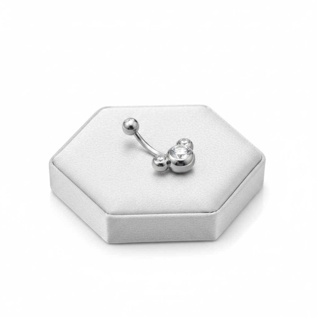 Clear Crystal Belly Button Ring in 316l stainless steel on a silver silk jewelry display.