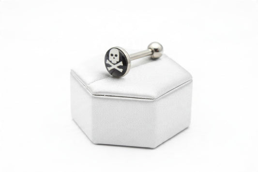 Skull & Crossbones Tongue Barbell in 316l stainless steel on a silver silk jewelry display.